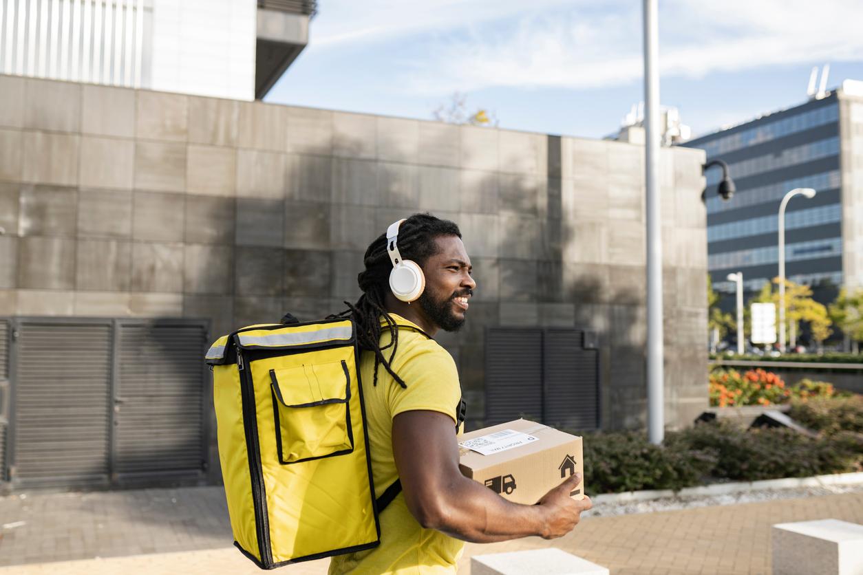 Delivery worker with headphones listening to audio content